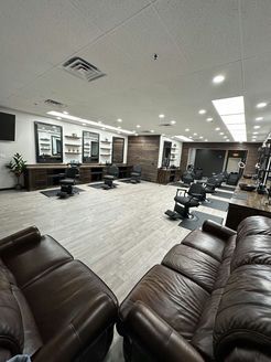 A barber shop with a couch and chairs in it.