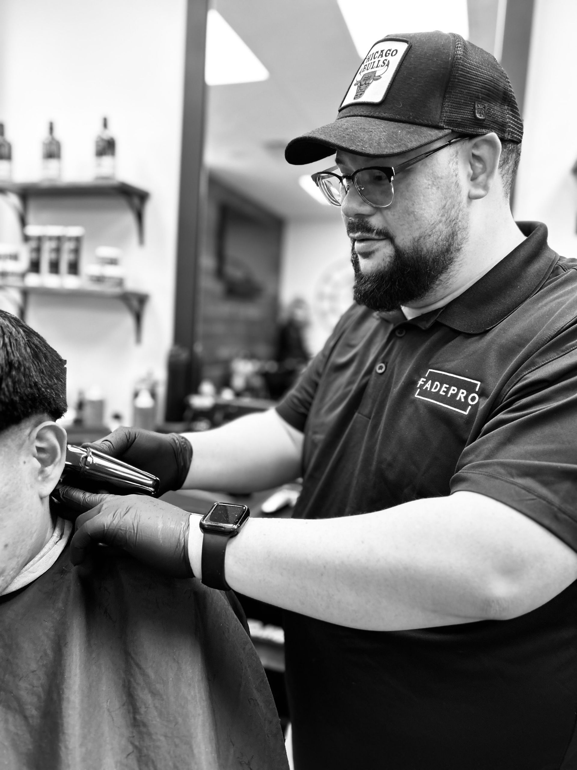 A woman is cutting a man 's hair in a barber shop.