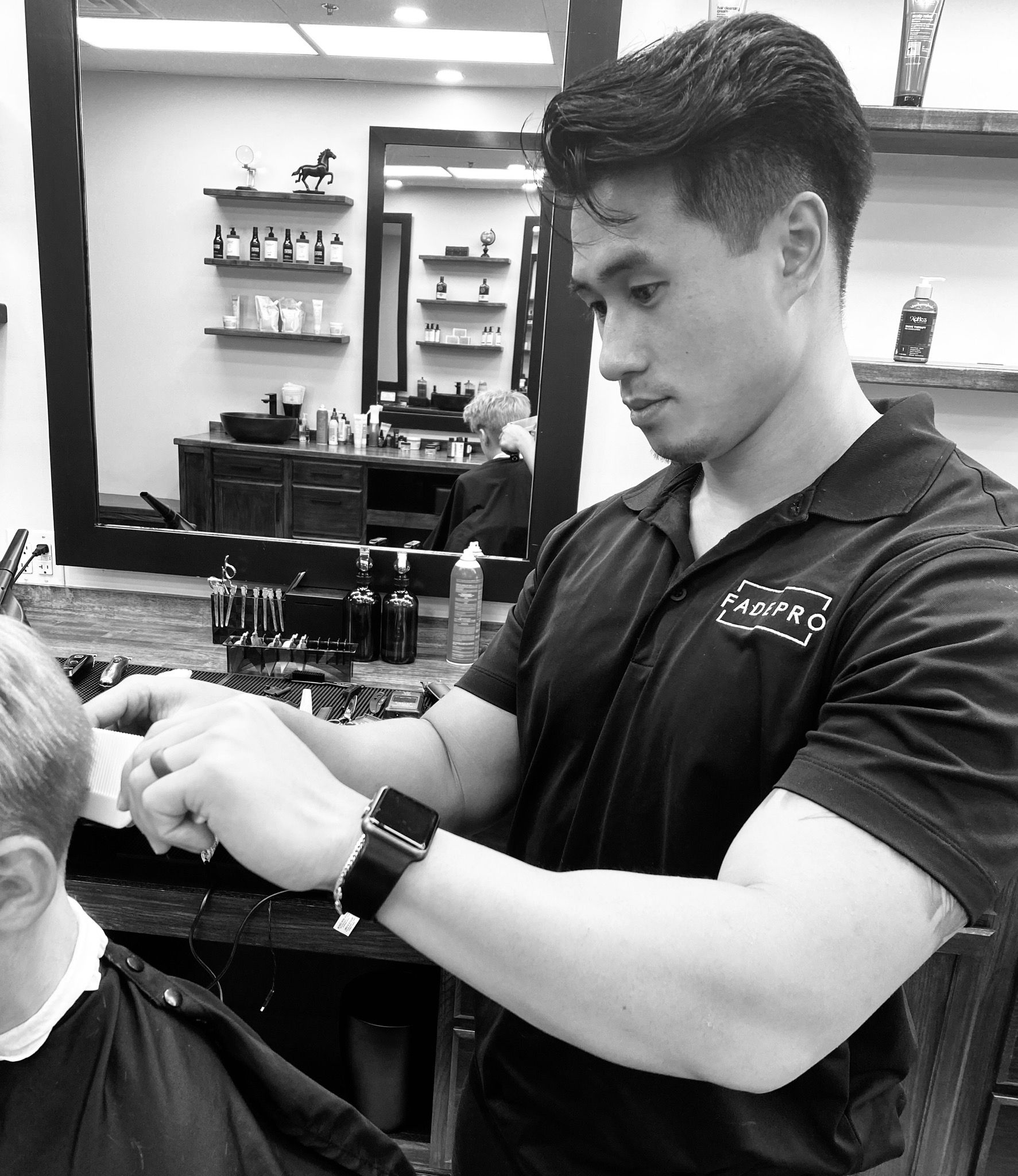 A man is getting his hair cut by a barber in a barber shop.