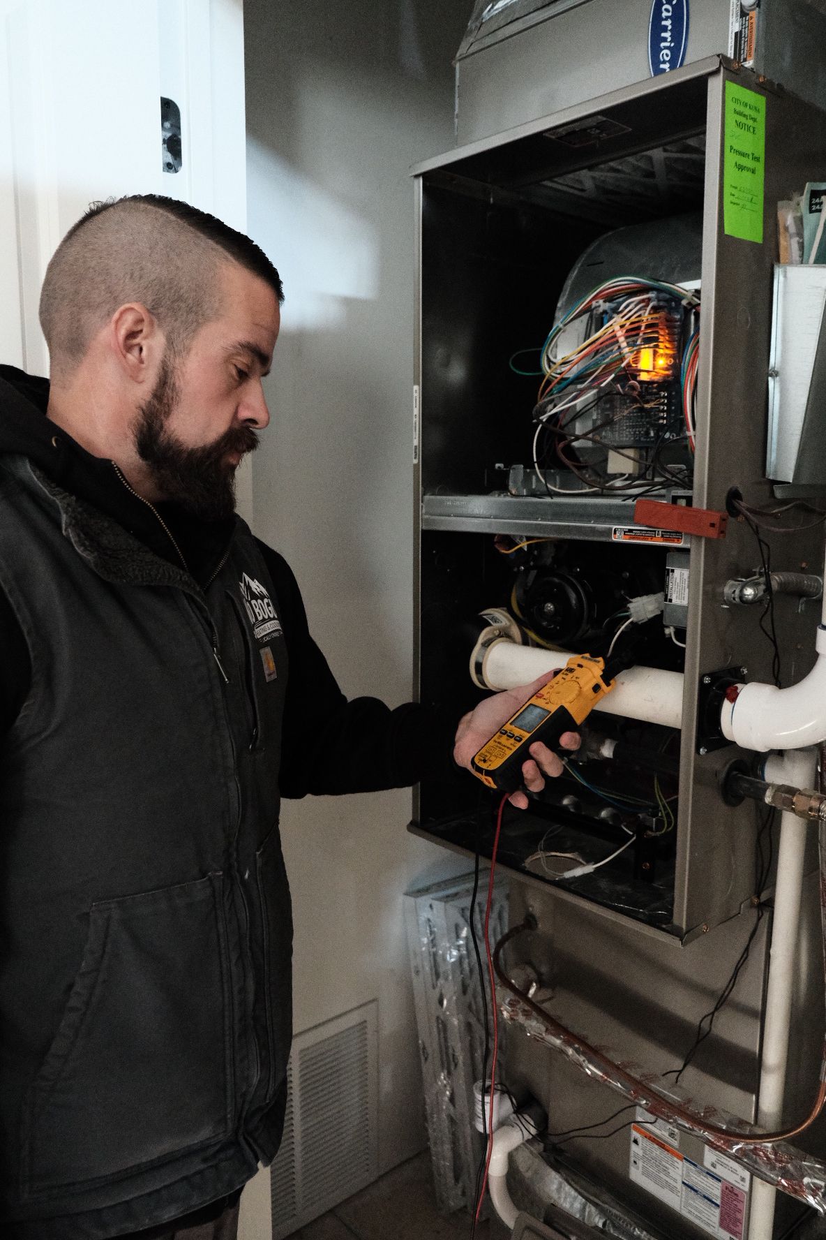 A man with a beard is working on a heating system.