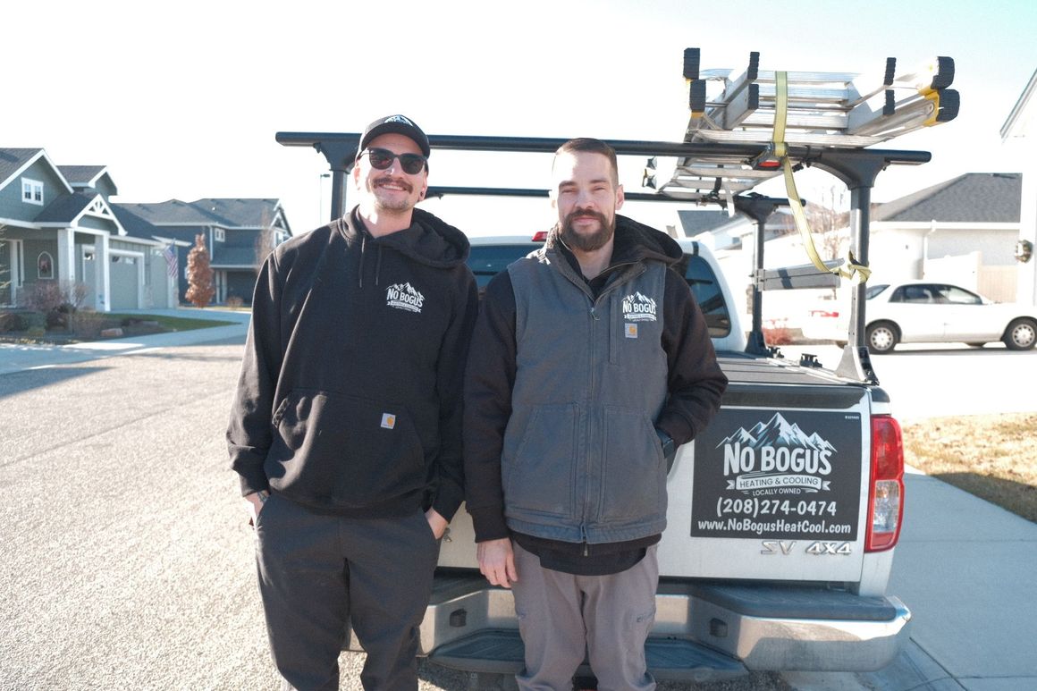 Two men are standing next to a truck that says no bogus on the back.