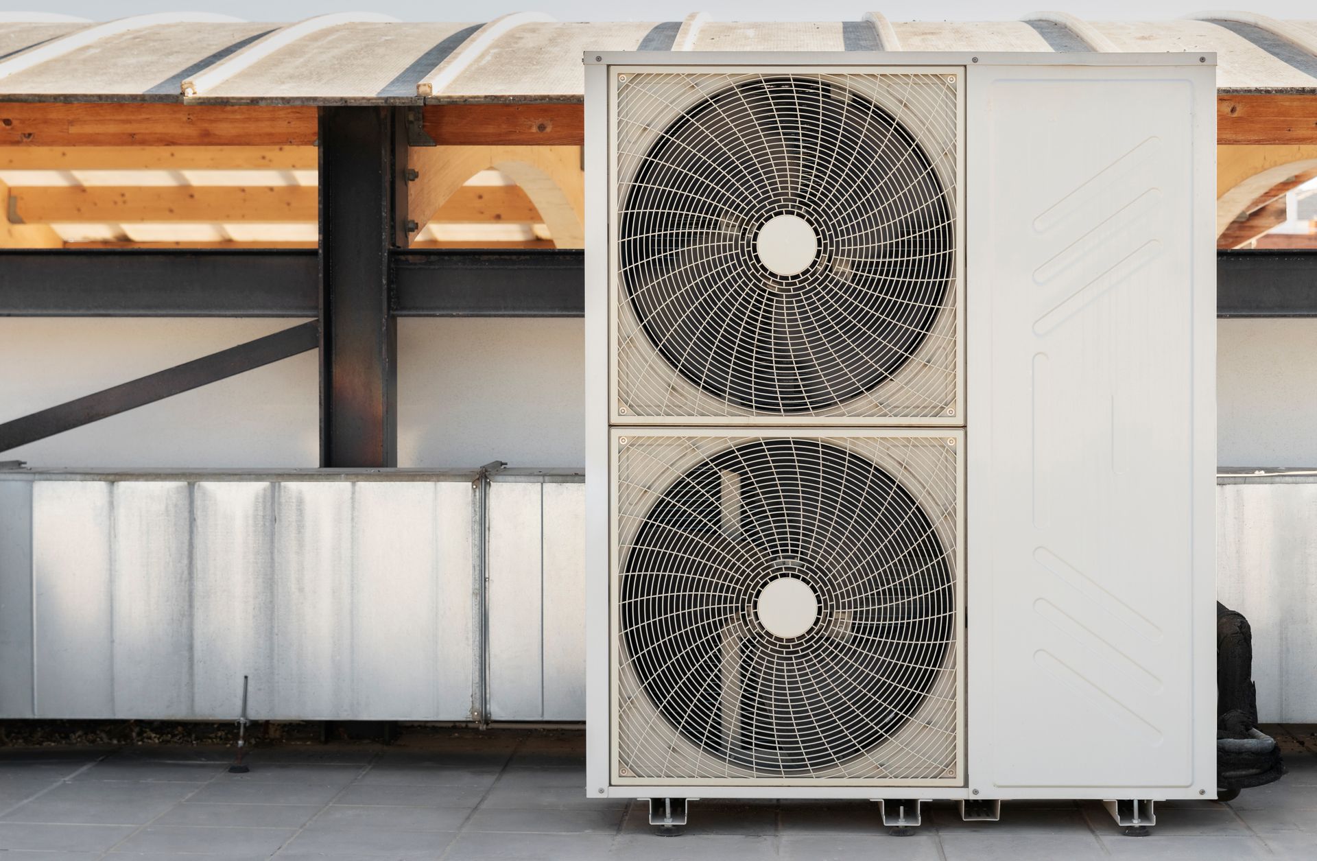 A large air conditioner is sitting on the side of a building.