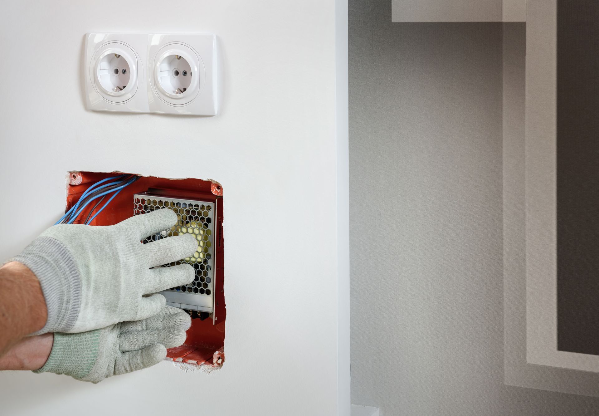 A person is installing a light switch in a wall.