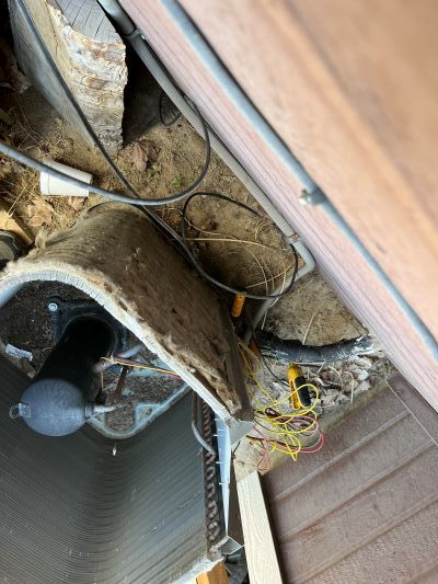 A picture of an air conditioner being repaired in a garage.