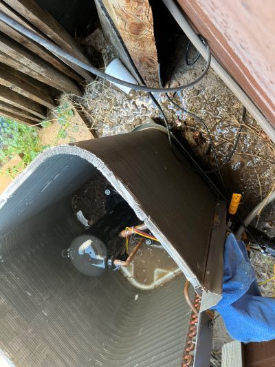 A person is working on an air conditioner in a garage.