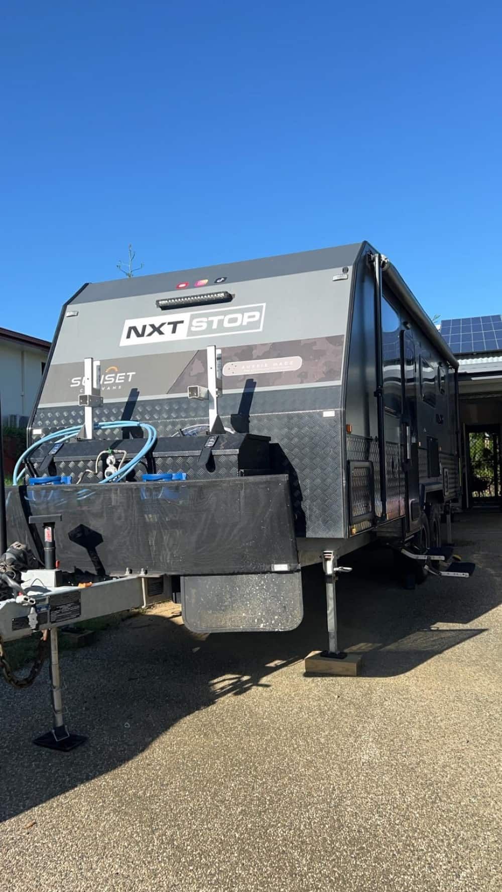 A Camper Trailer is Parked in a Driveway Next to a House  — APS Automotive Electrical in Marian, QLD