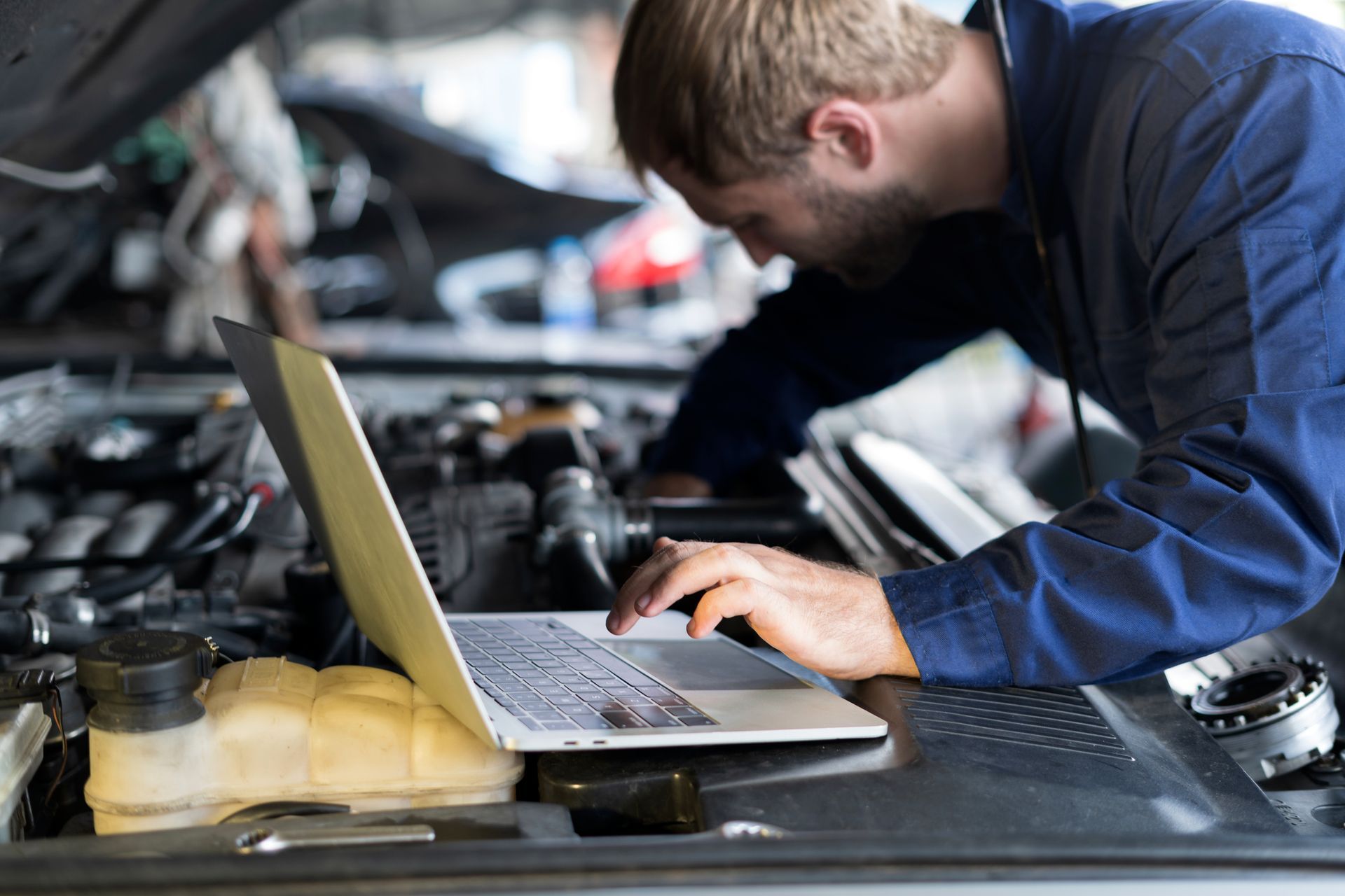 Mechanic checking car engine in an auto repair shop – Pike, MD – Lynn's Automotive