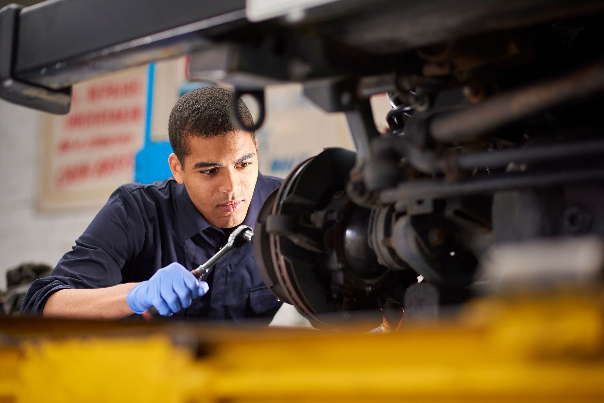 Mechanic repairing car brakes in an auto repair shop – Pike, MD – Lynn's Automotive