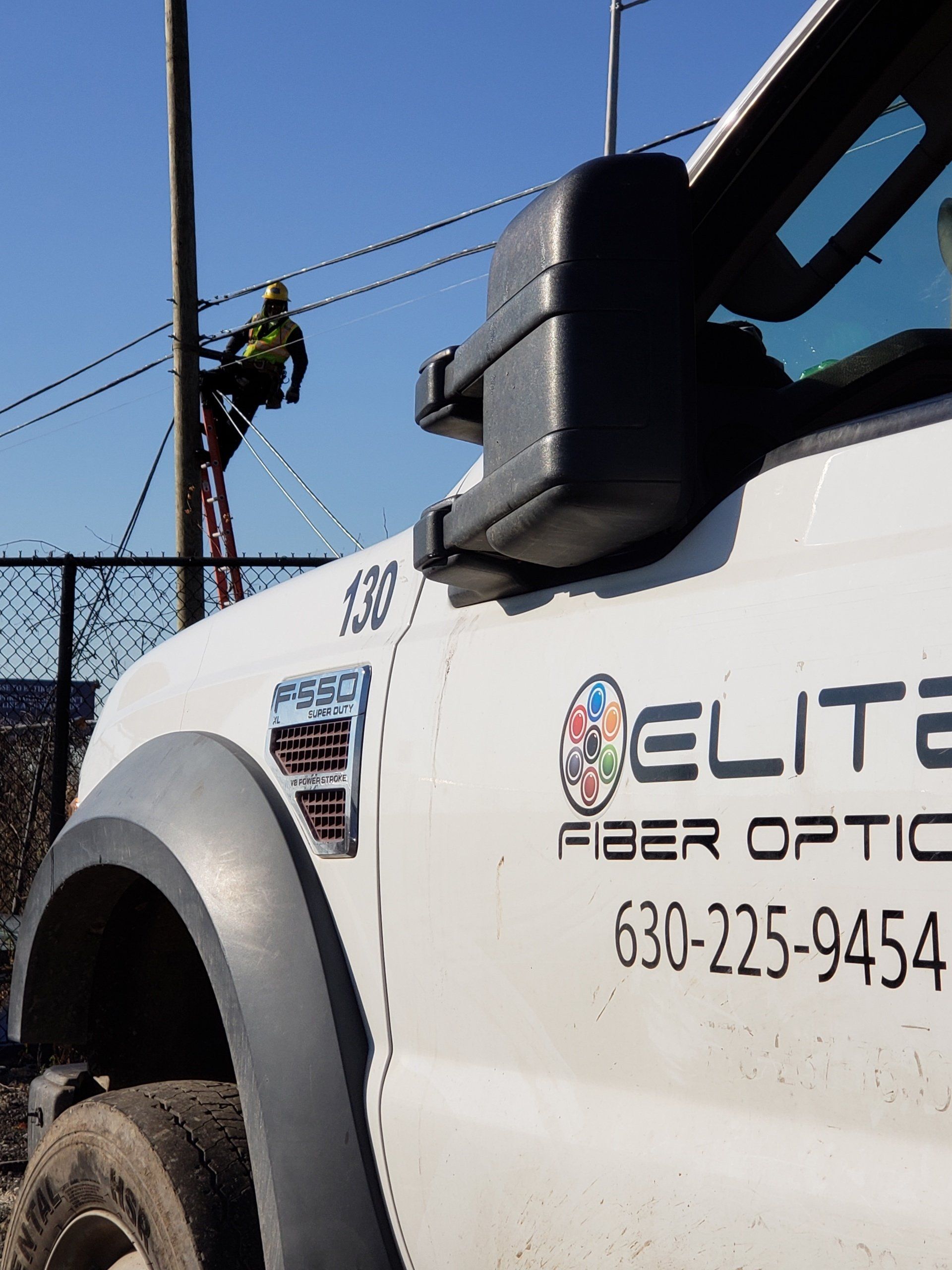 A white truck that says elite fiber optic on the side