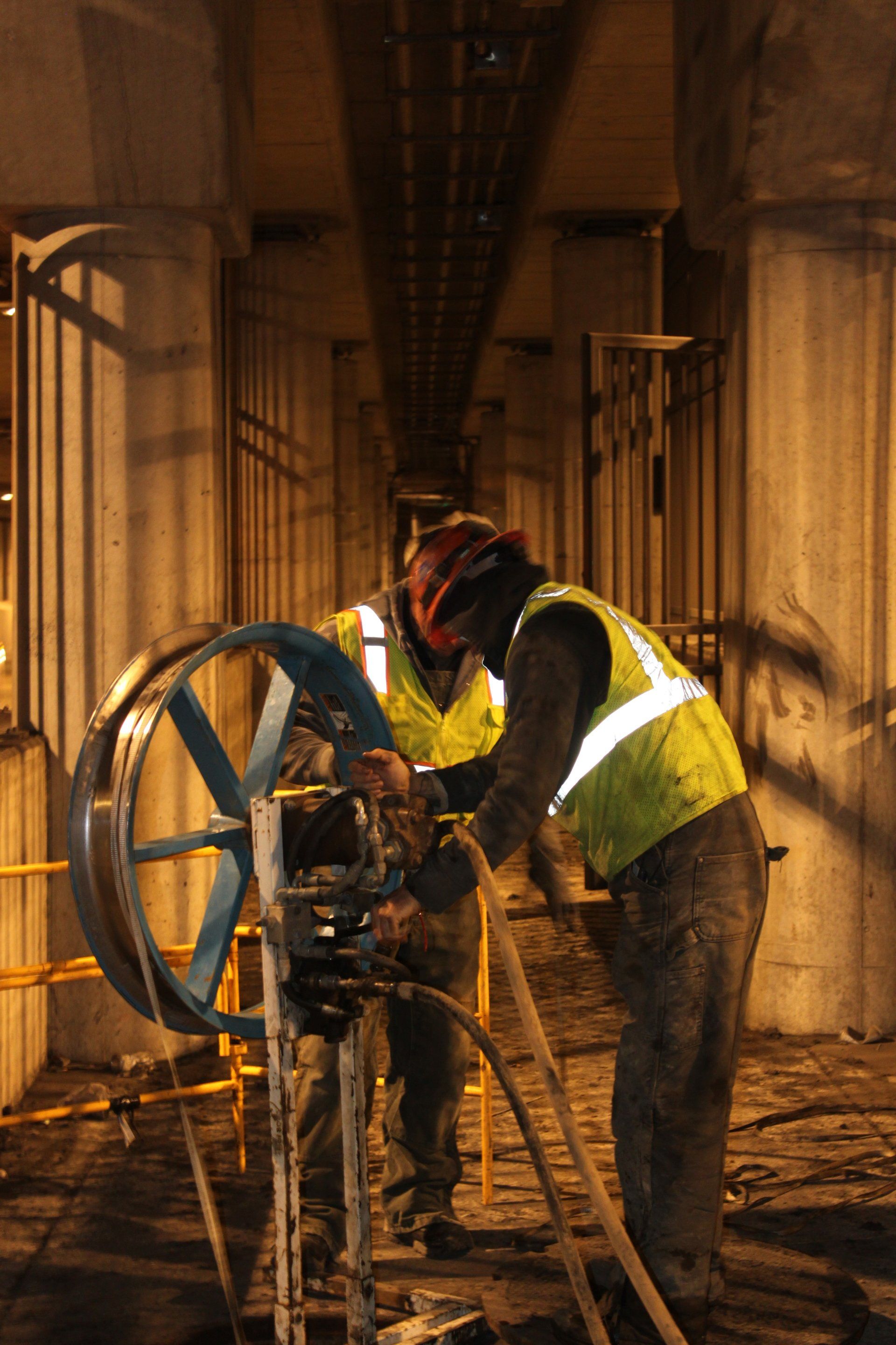 Two men are working on a machine in a dark room.