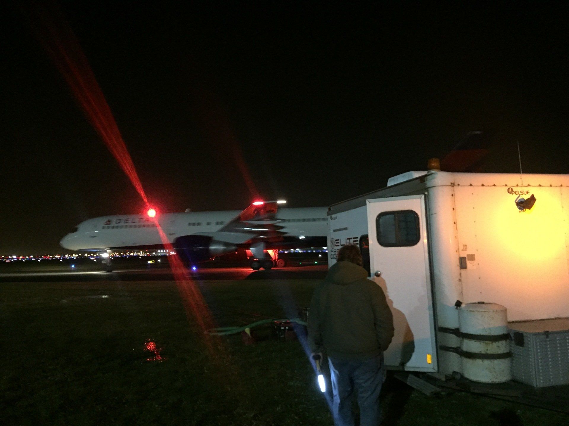 A united airlines plane is parked on the runway at night