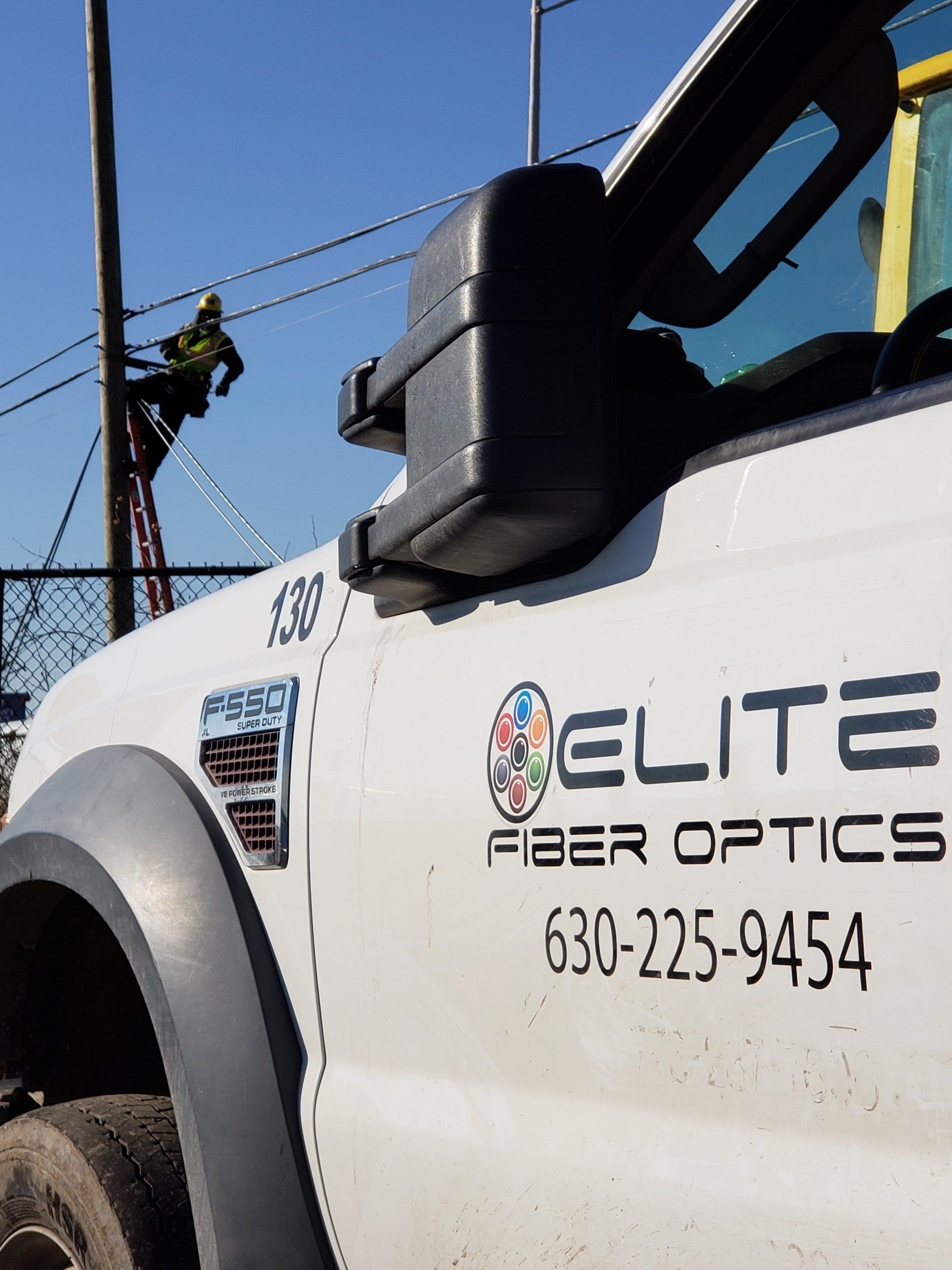 A white truck with elite fiber optics written on the side
