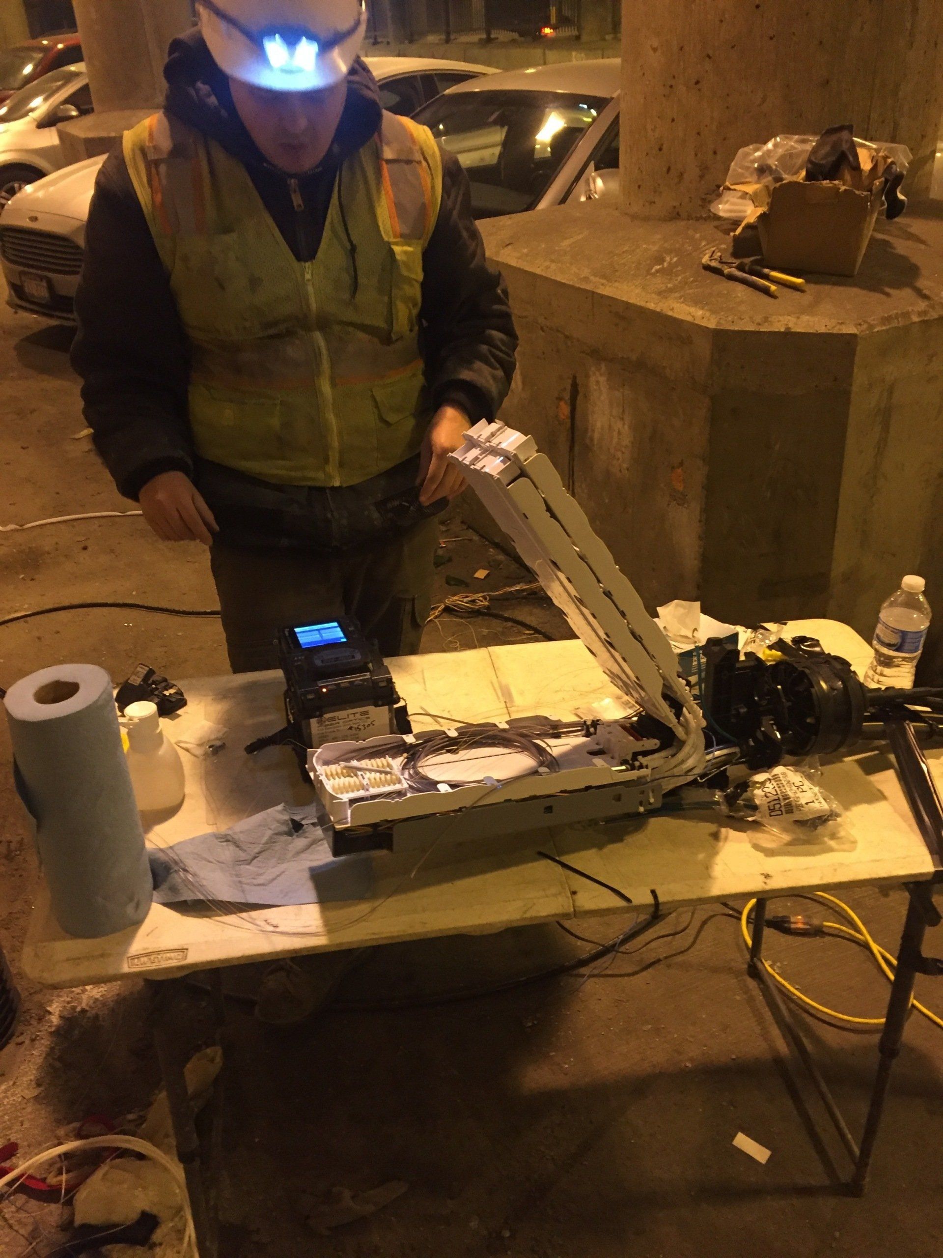 A man wearing a hard hat is working on a machine