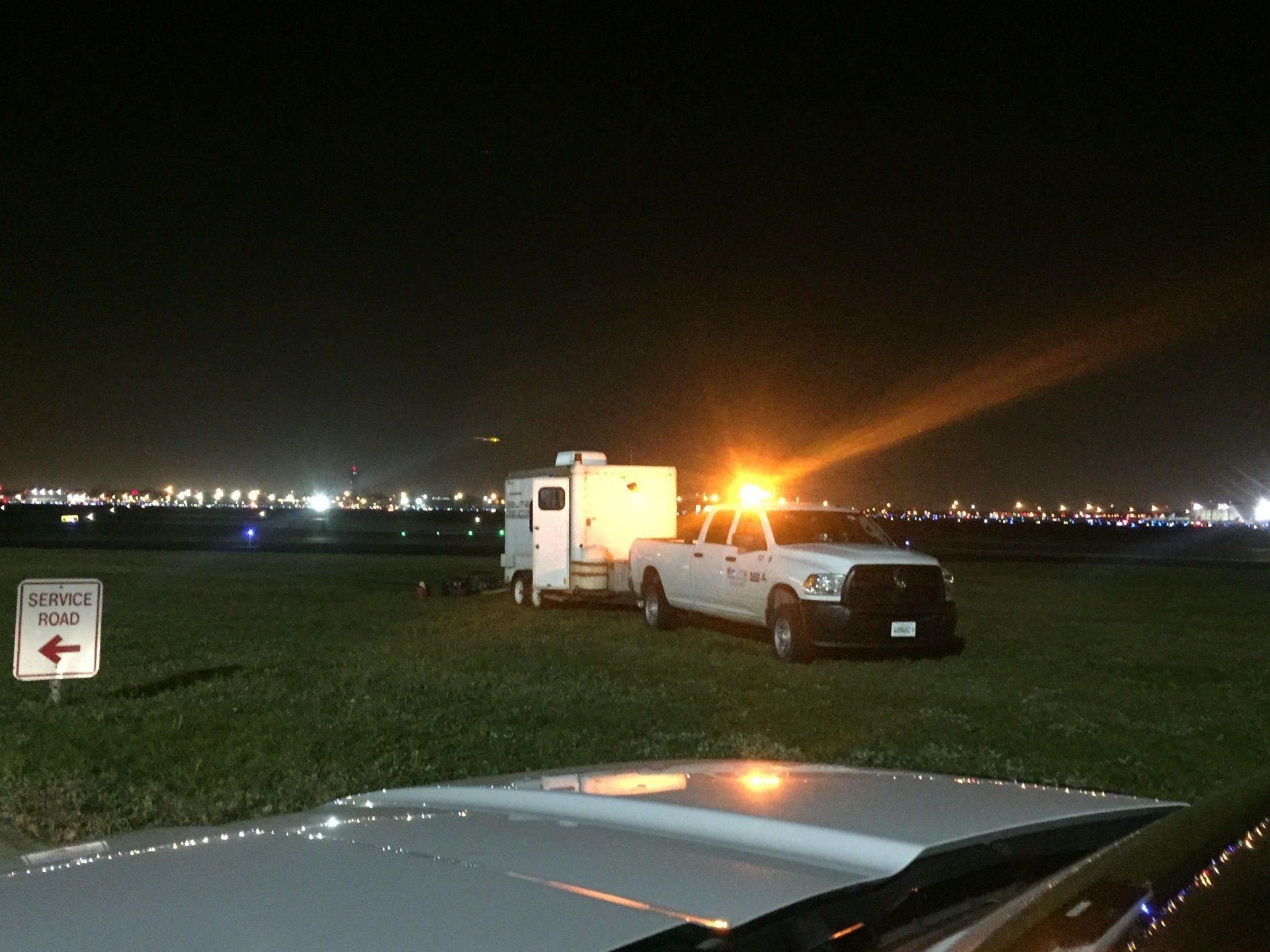 A truck and trailer are parked in a field at night