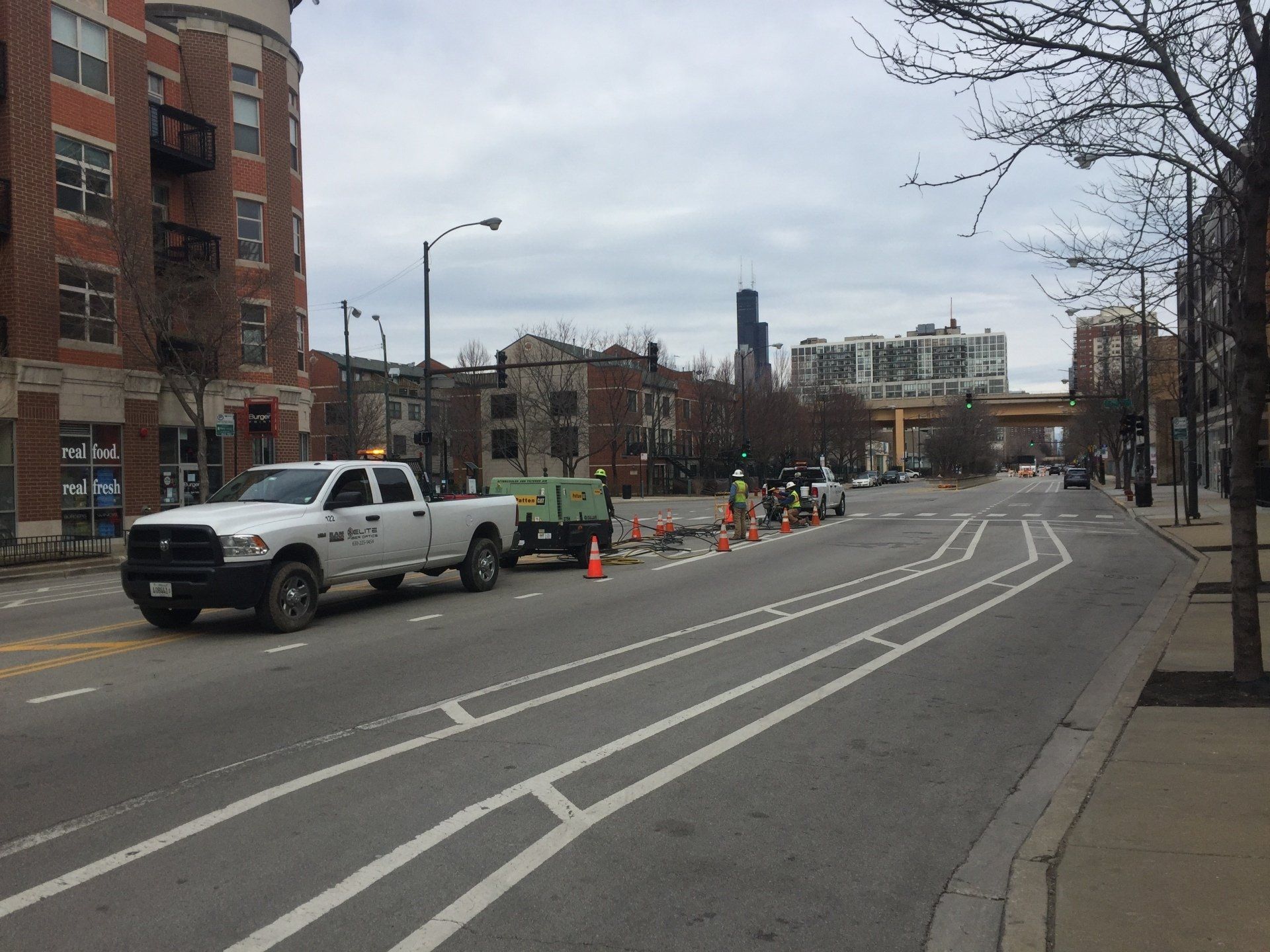 A white truck is parked on the side of a city street.