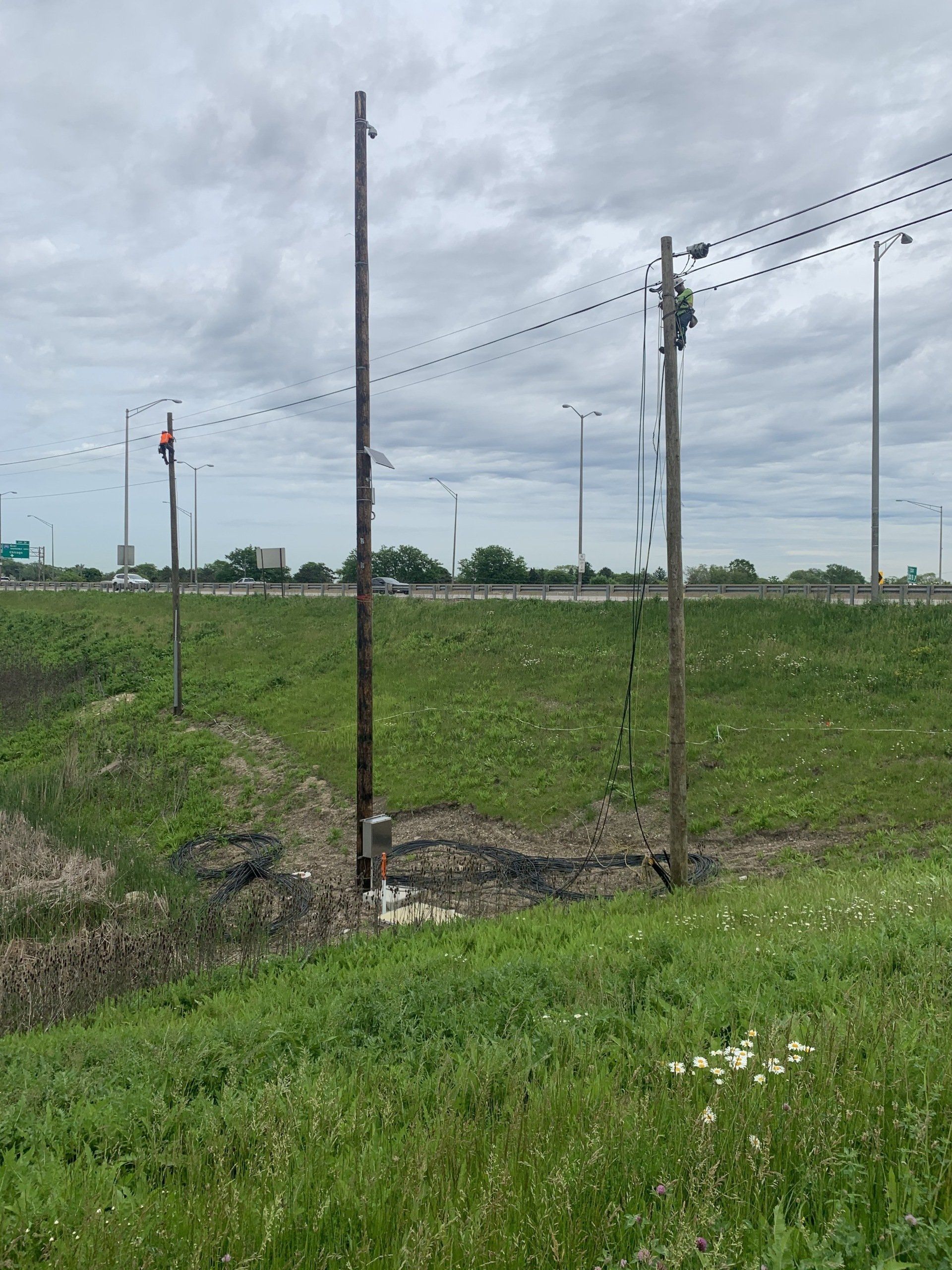 A telephone pole in the middle of a grassy field.