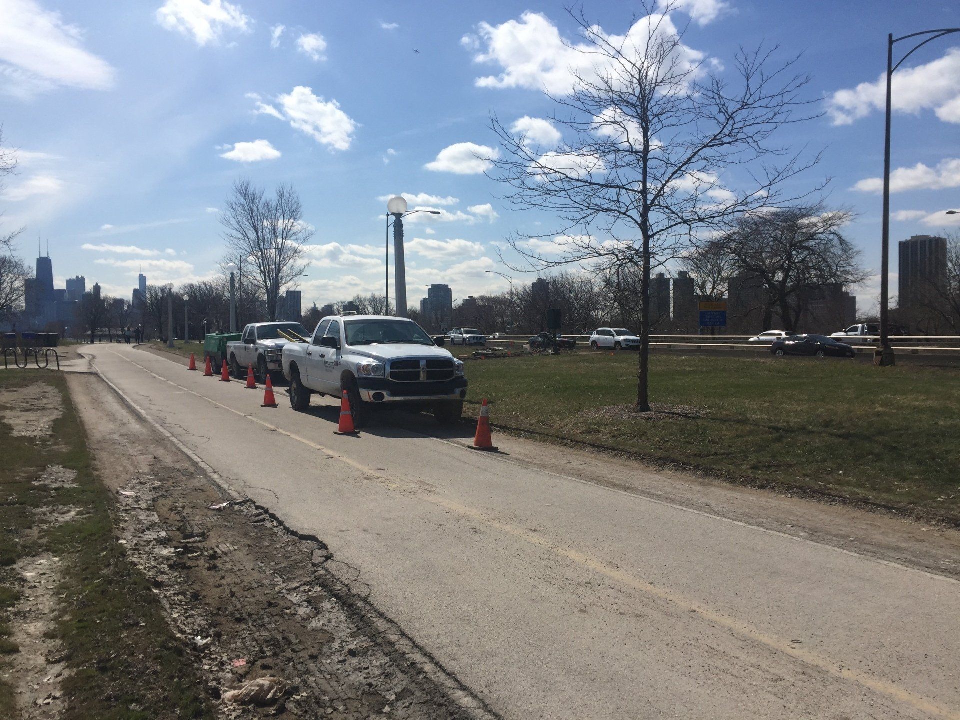 A row of white trucks are parked on the side of a road