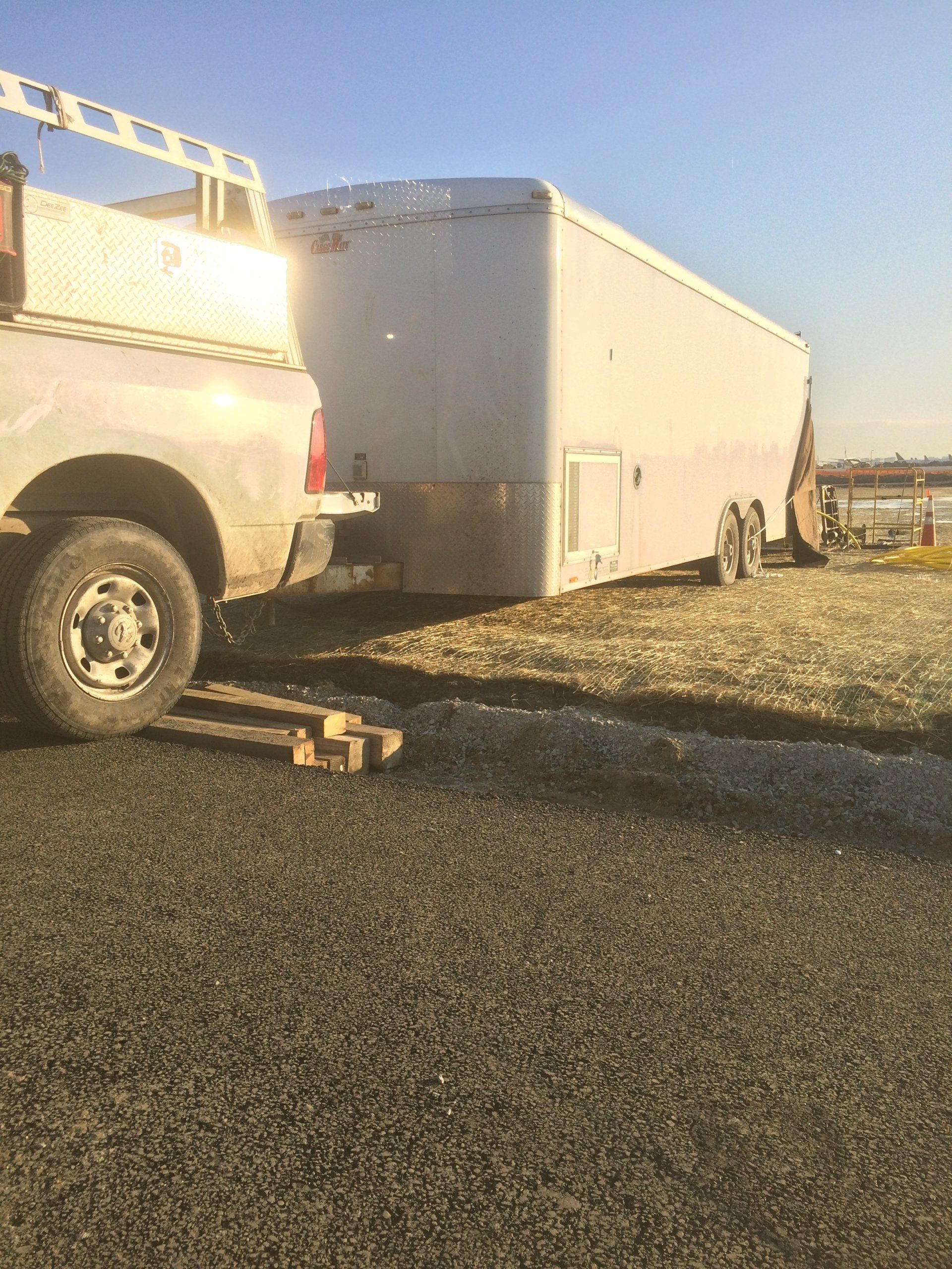 A truck with a trailer attached to it is parked on the side of the road.