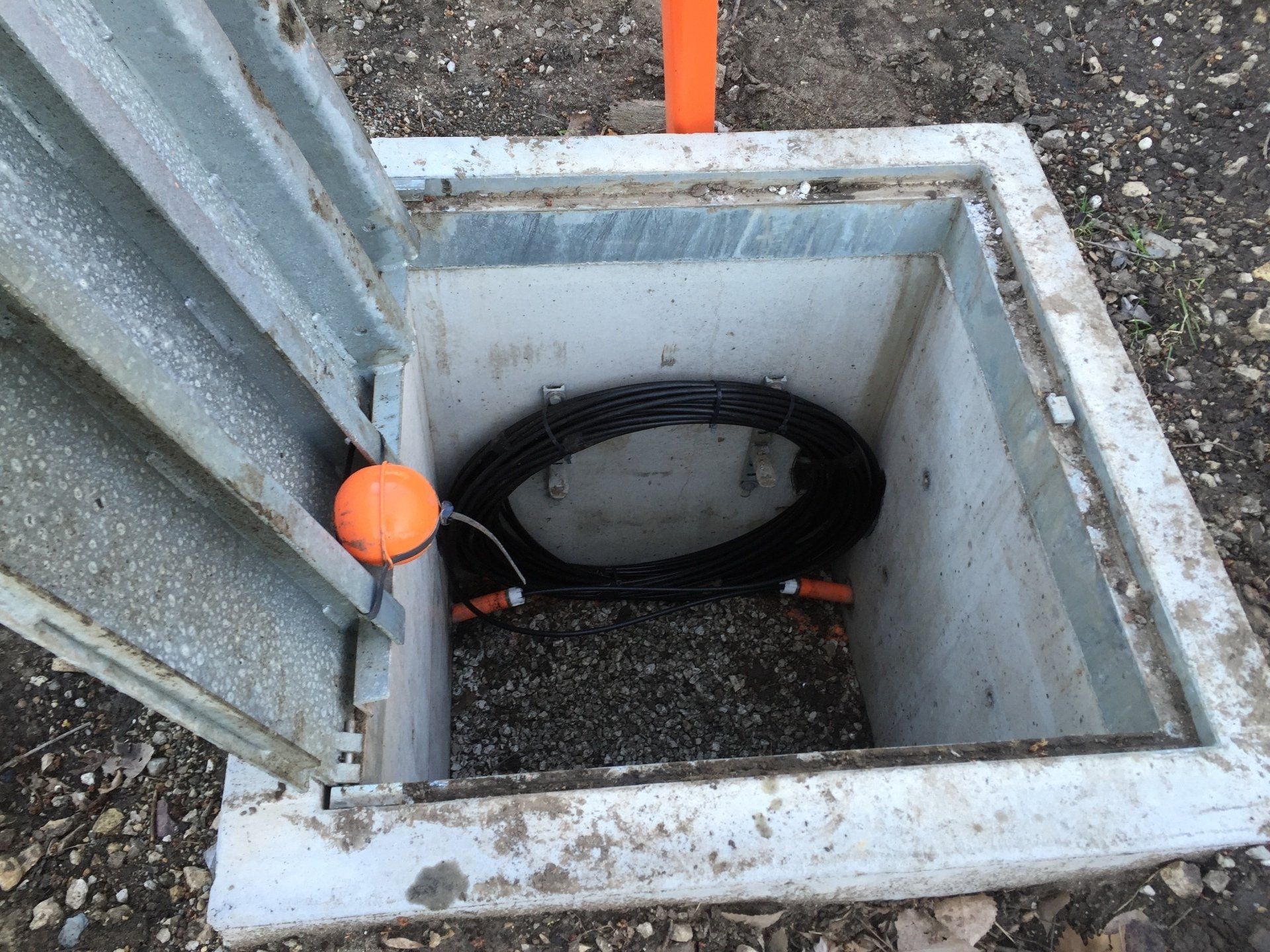 A manhole cover with a hose inside of it.