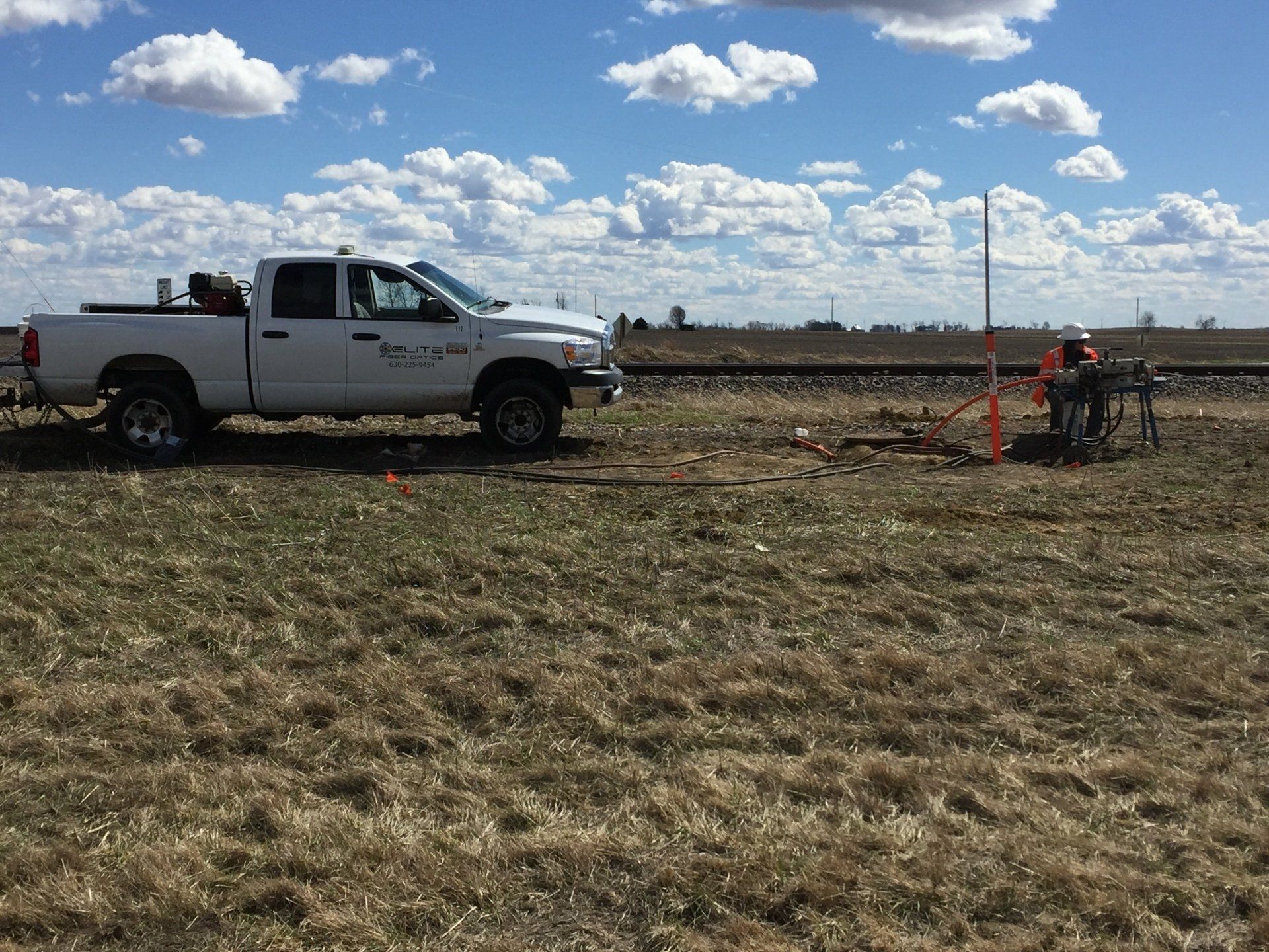 A white truck is parked in the middle of a field.