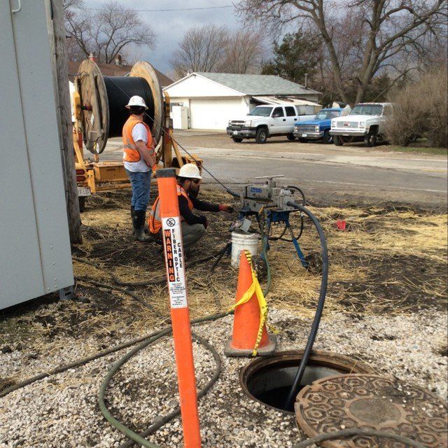 A man standing next to an orange pole with a sticker on it that says ' safety '