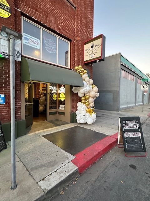 A store front with balloons and a sign that says wine