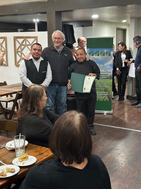 A group of people standing around a table with plates of food