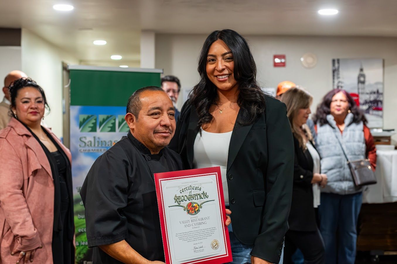 A man and a woman are standing next to each other holding a certificate.
