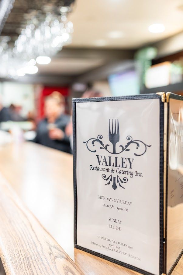 A menu is sitting on a wooden counter in a restaurant.
