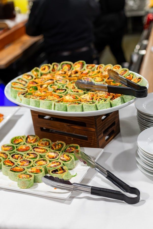 A plate of food with tongs on a table.