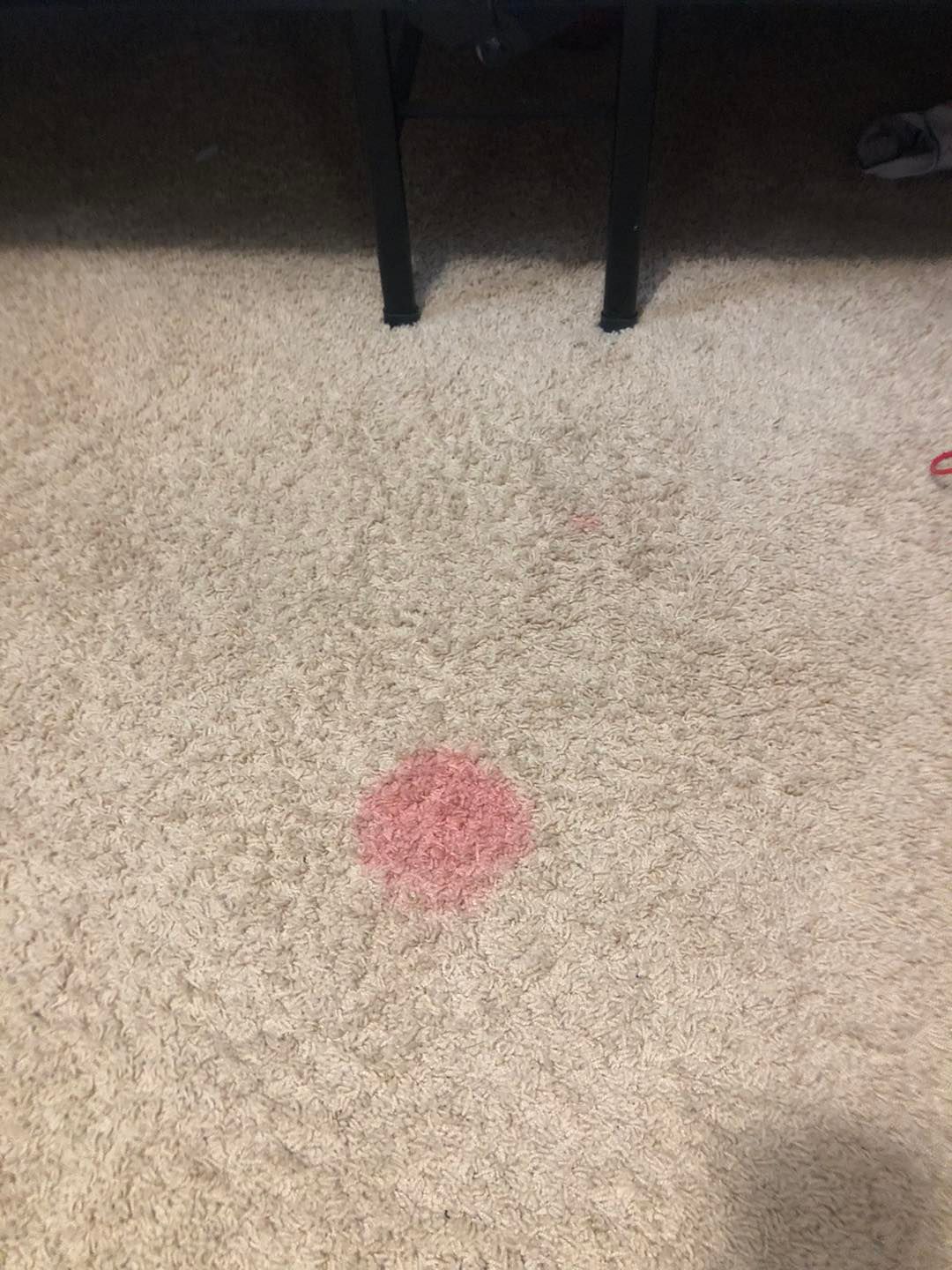 There is a red spot on the carpet.