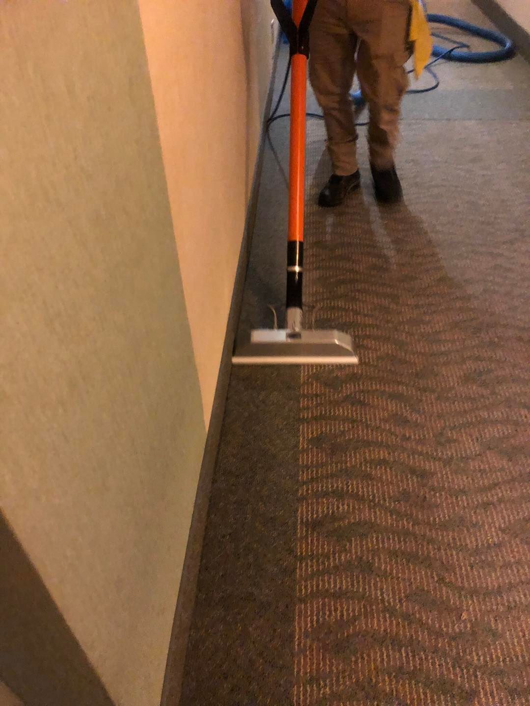A person is cleaning a hallway with a mop