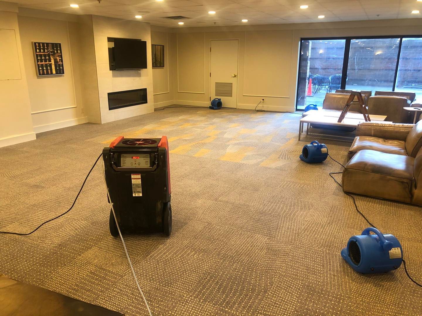 A large room with a lot of furniture and a vacuum cleaner in it.