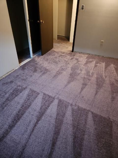 A room with a purple carpet and a door.