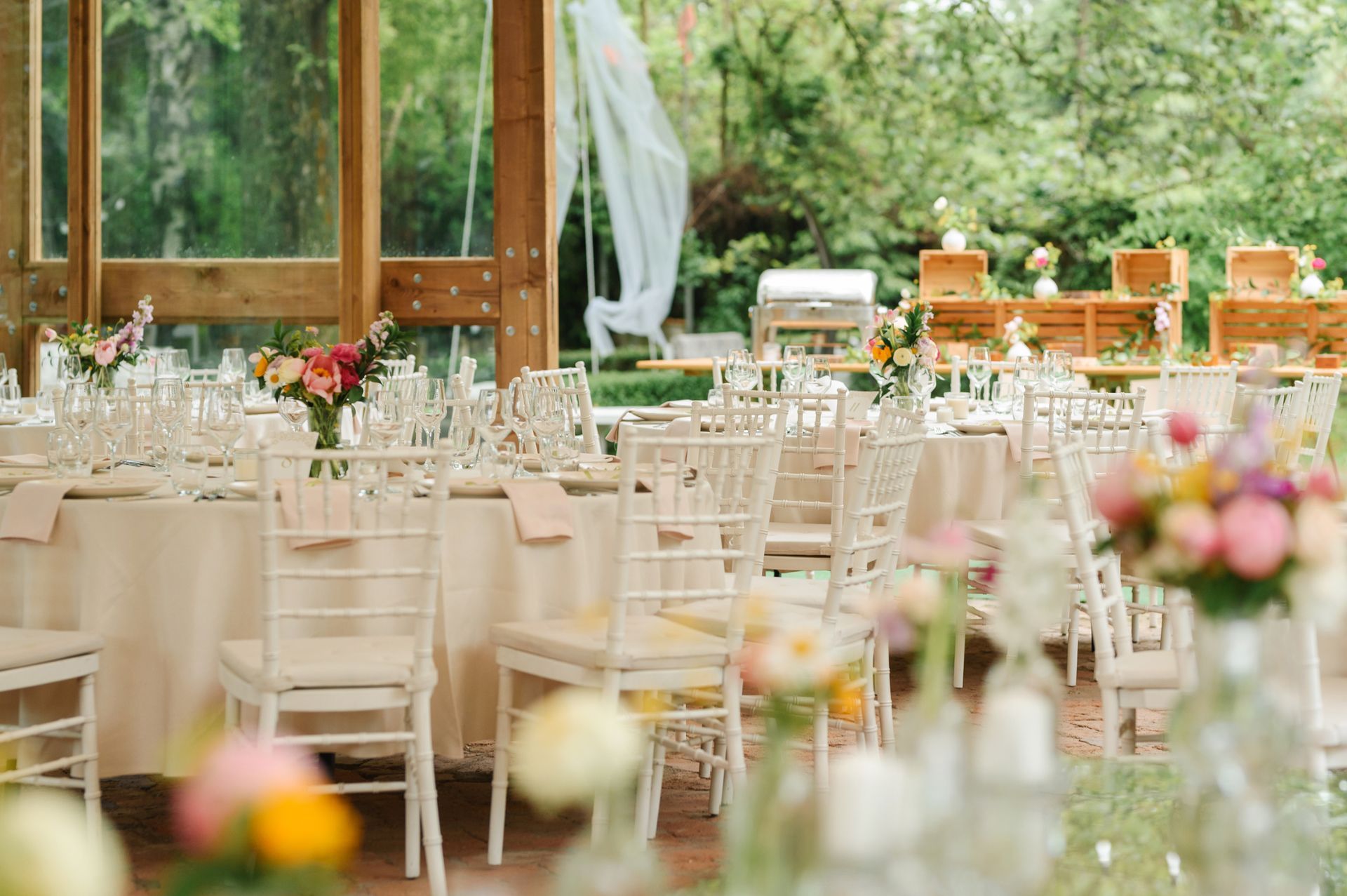 A row of tables and chairs set up for a wedding reception.