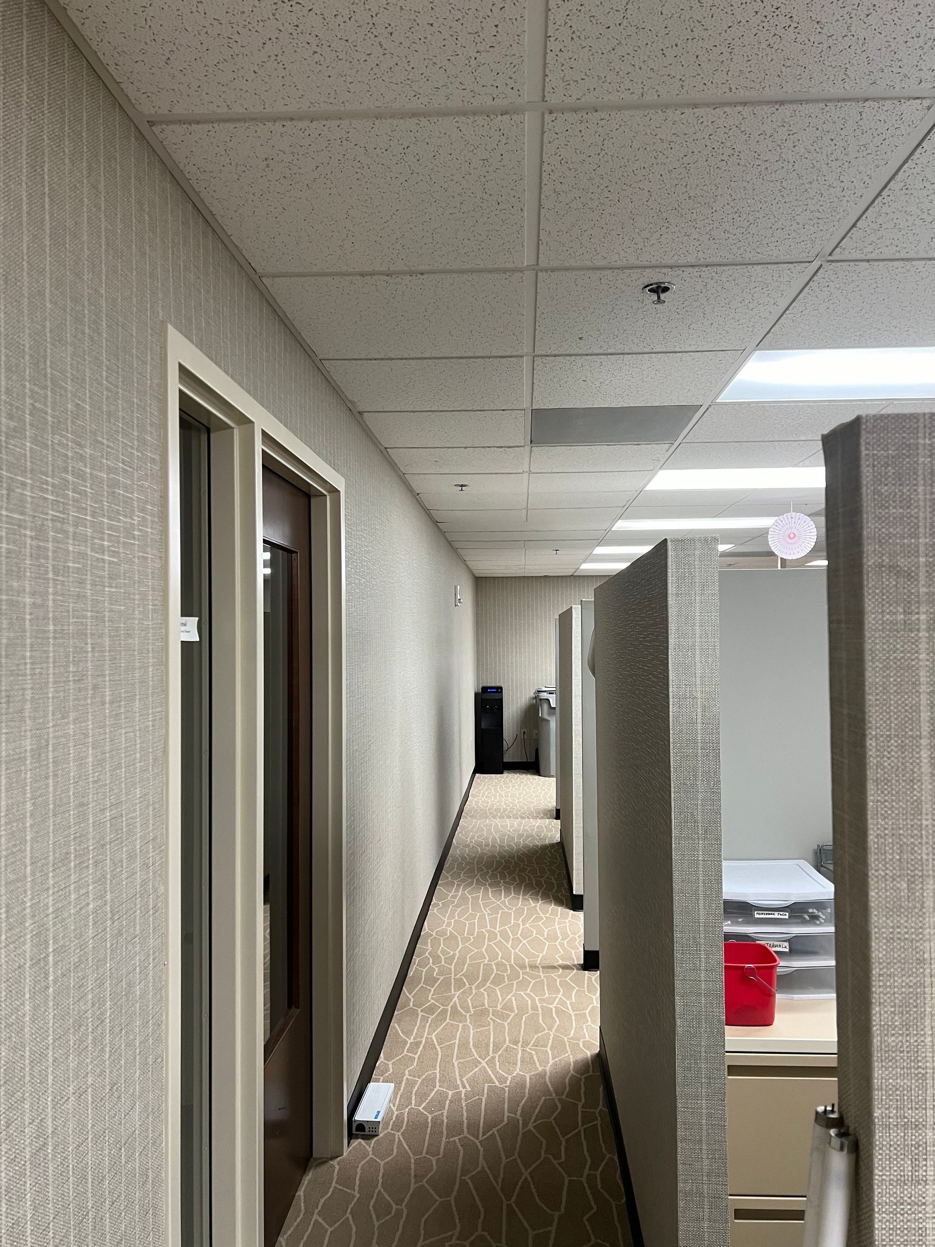 A long hallway between two cubicles in an office building.