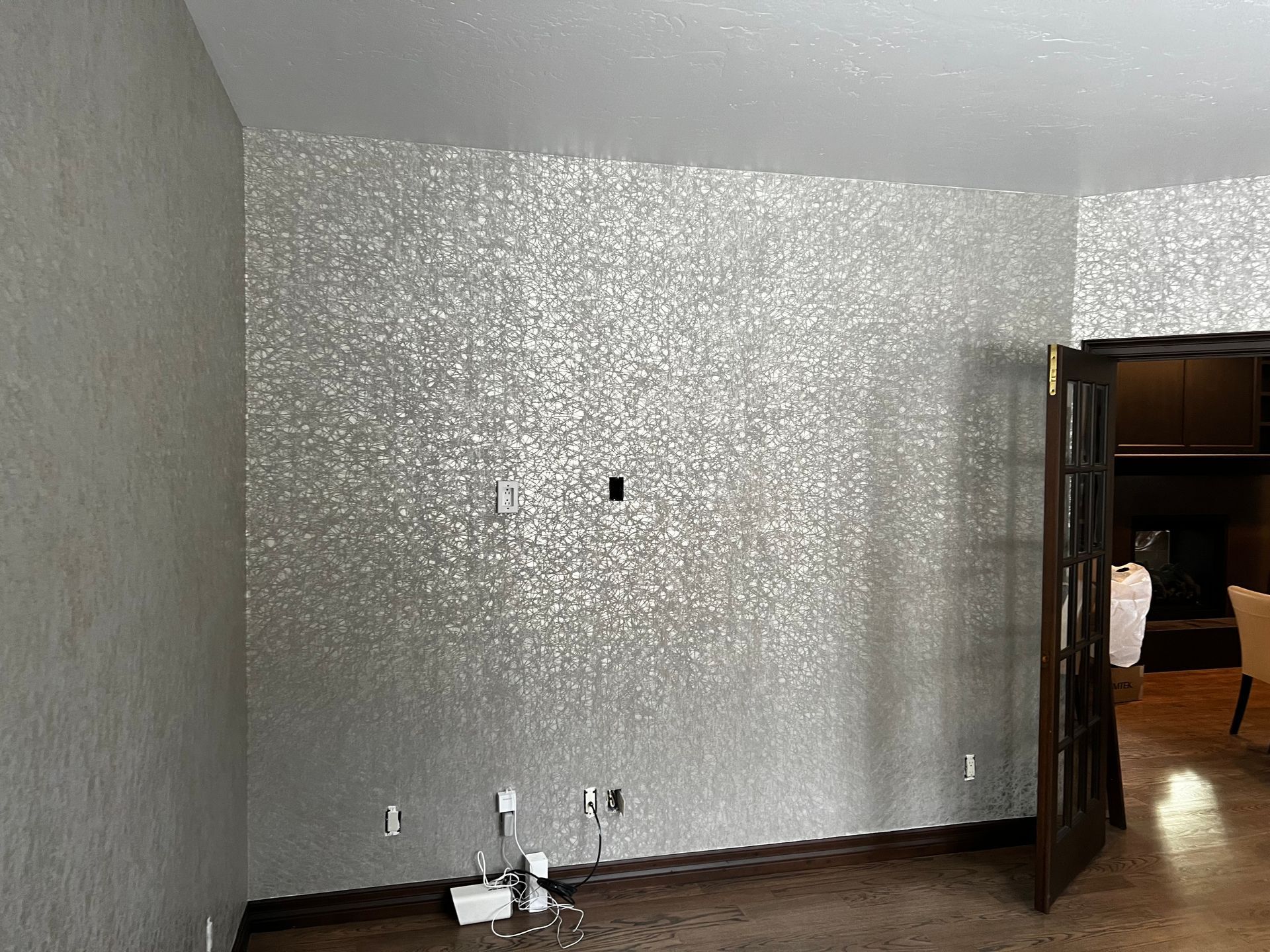 An empty room with a silver wall and a door.