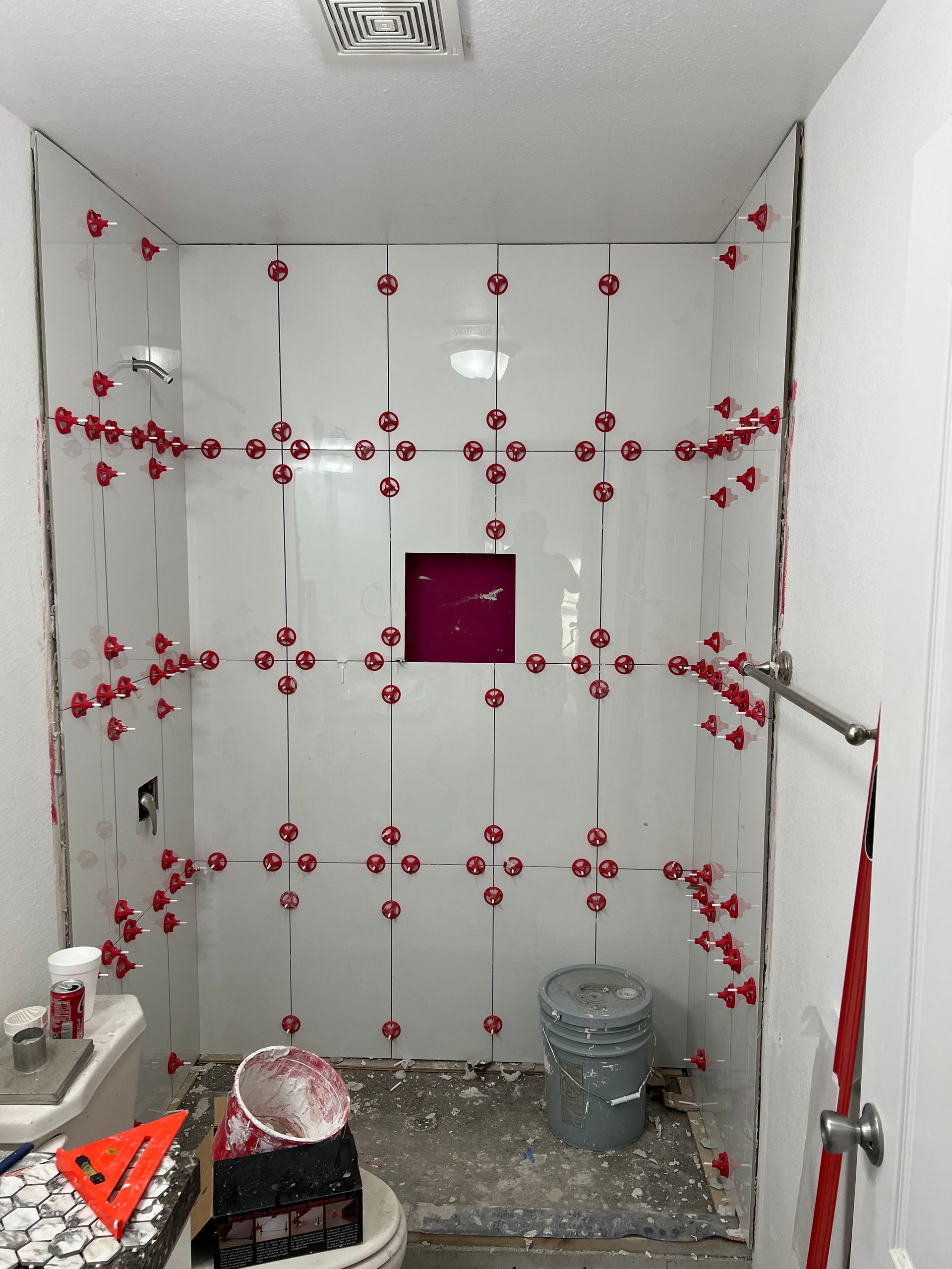 A bathroom under construction with a toilet and a trash can