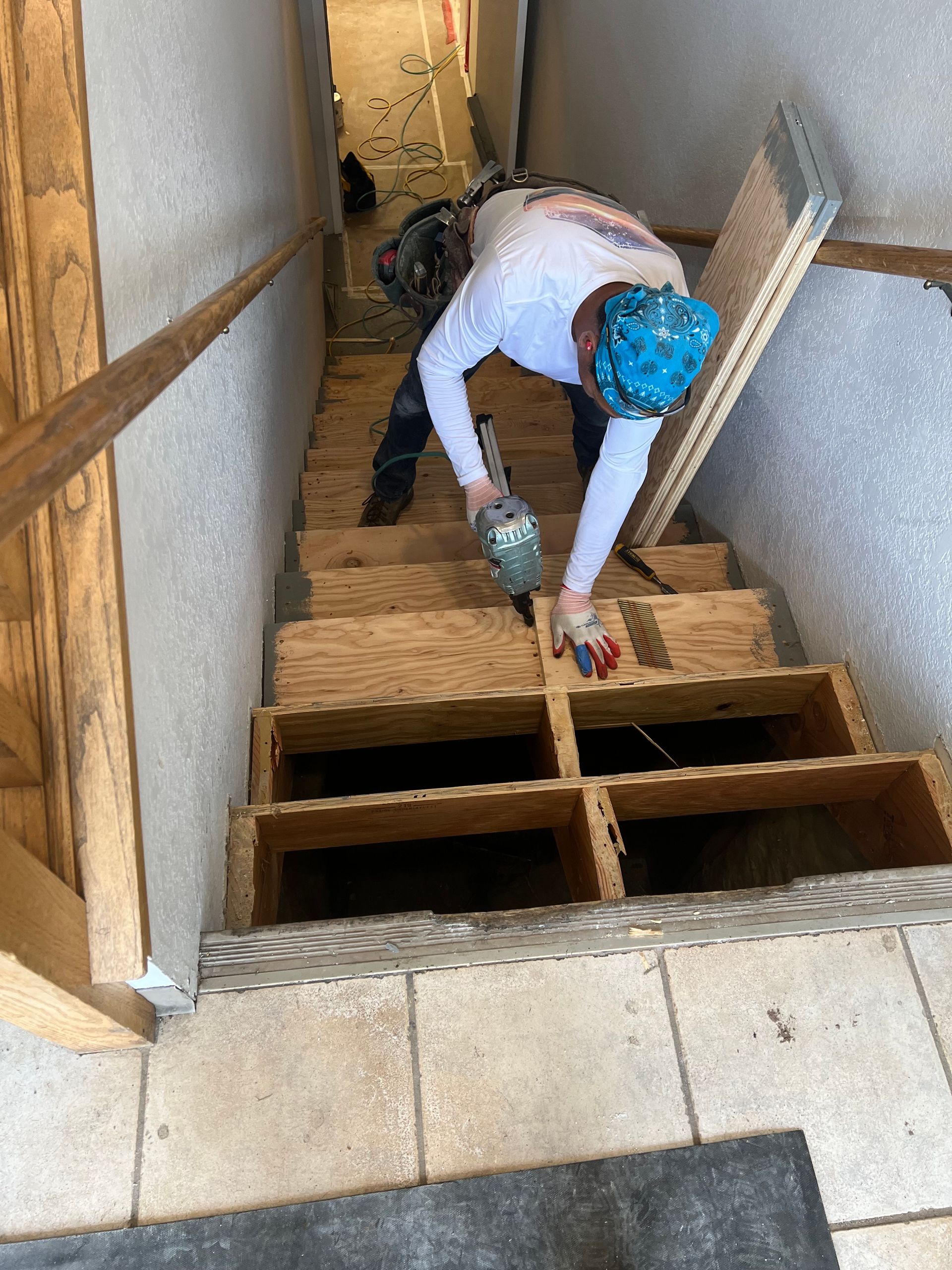 A man is working on a set of wooden stairs.