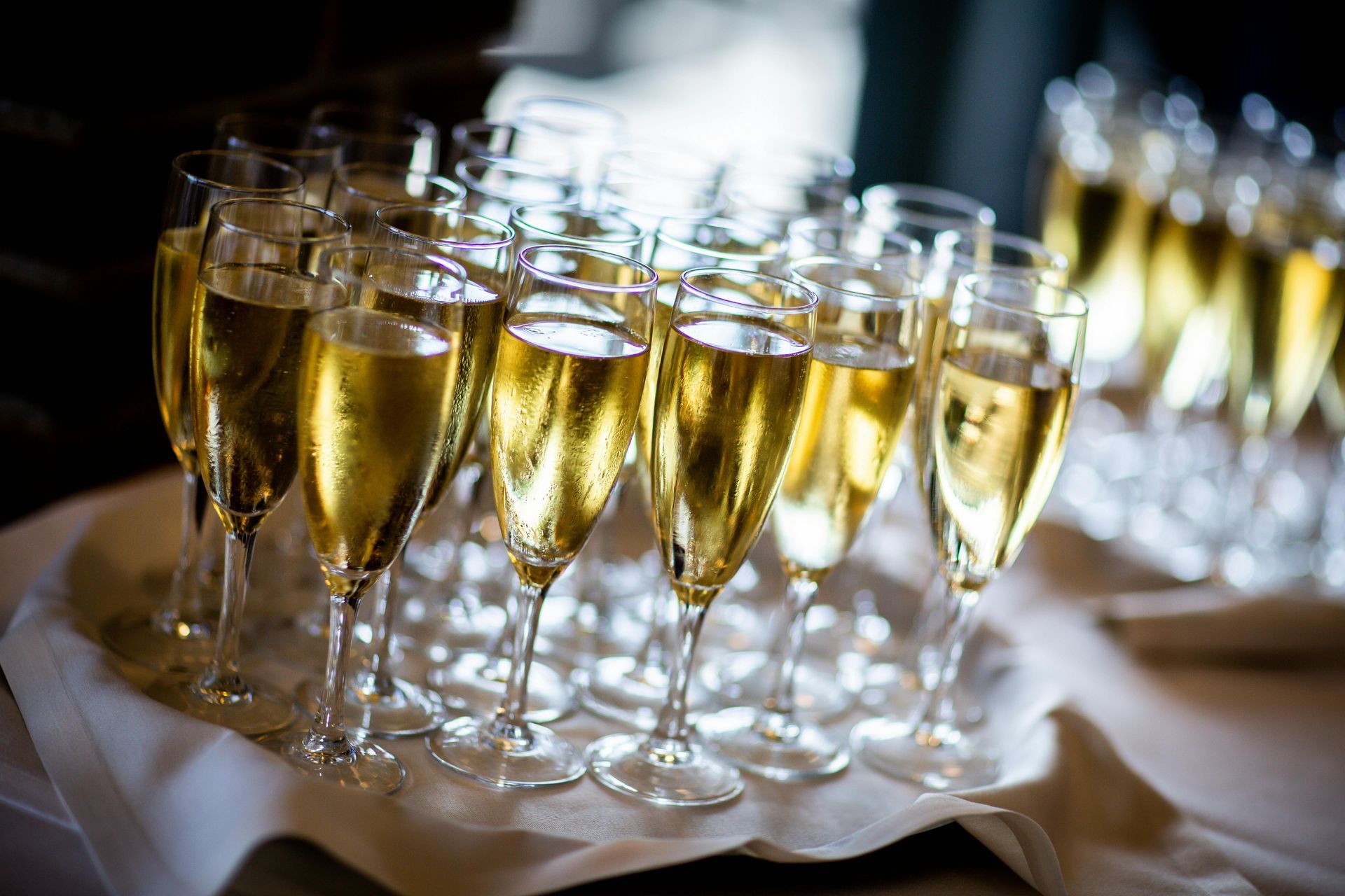 A tray of champagne glasses filled with champagne on a table.