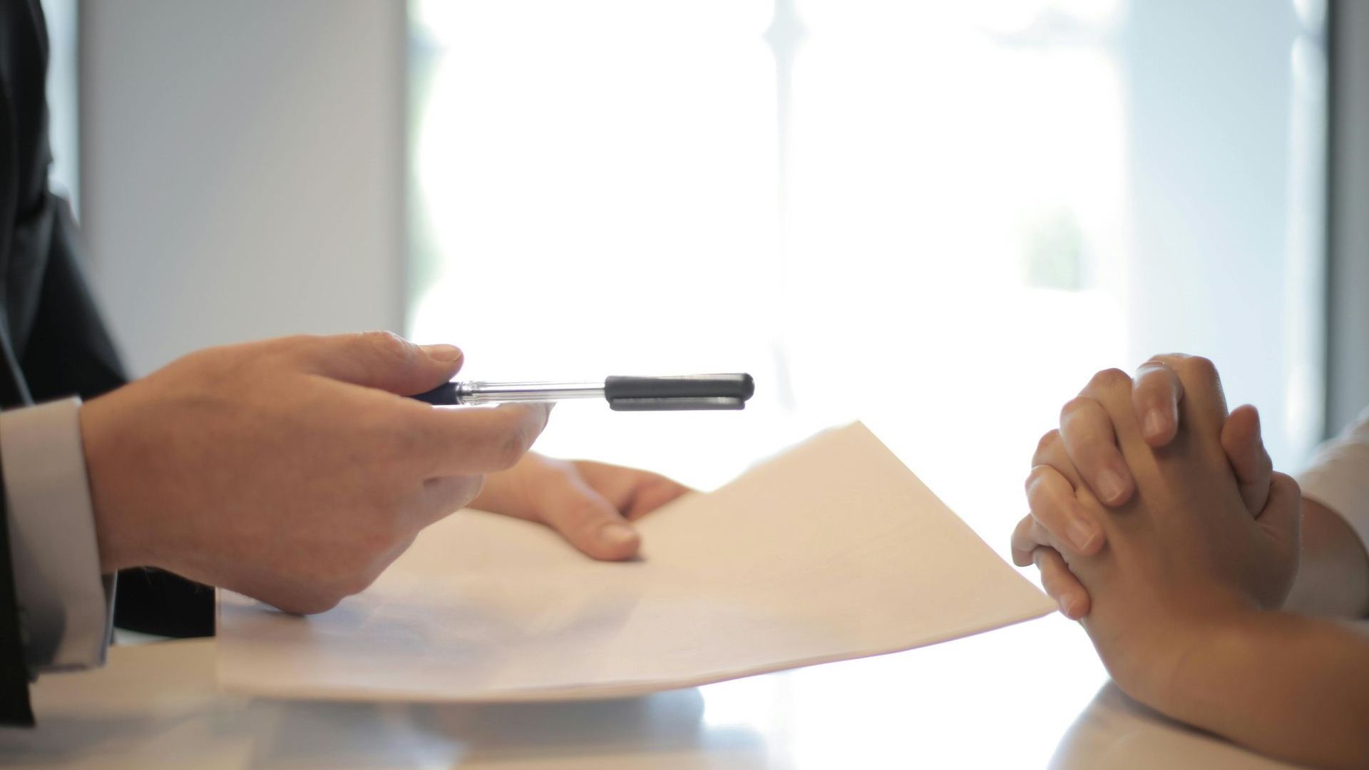 A man is giving a piece of paper to a woman.