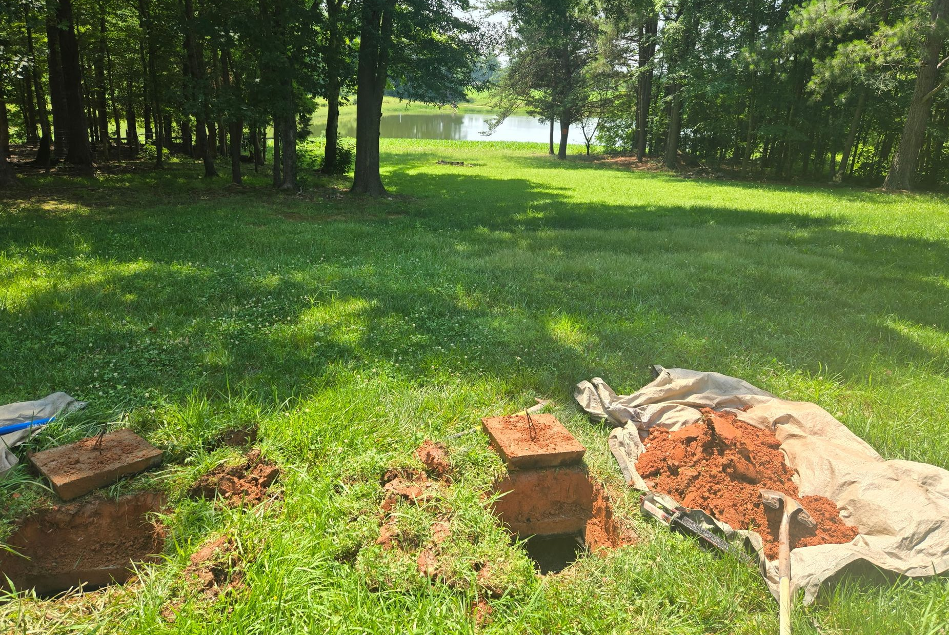 Open manhole with red hose extending inside, concrete surrounding. Open manhole with red hose extending inside, concrete surrounding.
