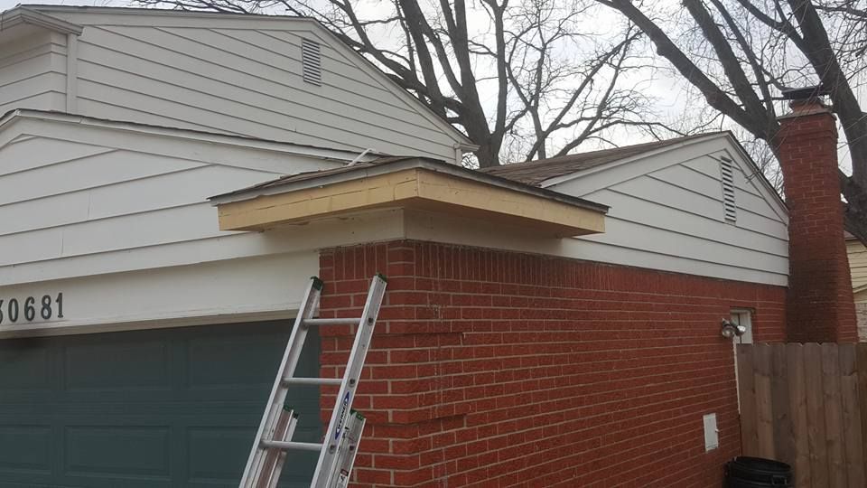 A ladder is sitting on the side of a brick house.