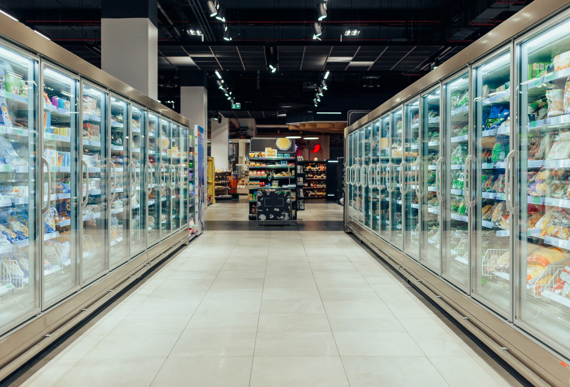 The inside of a grocery store with a lot of refrigerators.