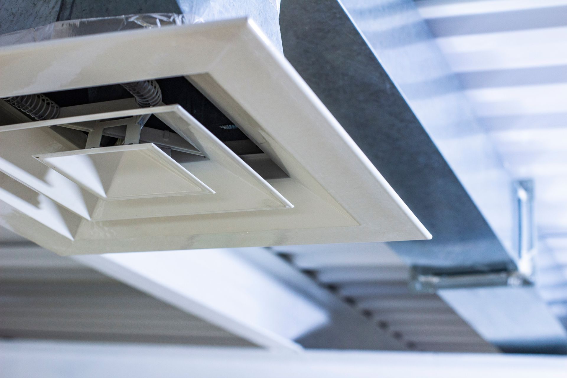 An image showing a square anemostat installed on a galvanized duct ventilation system.