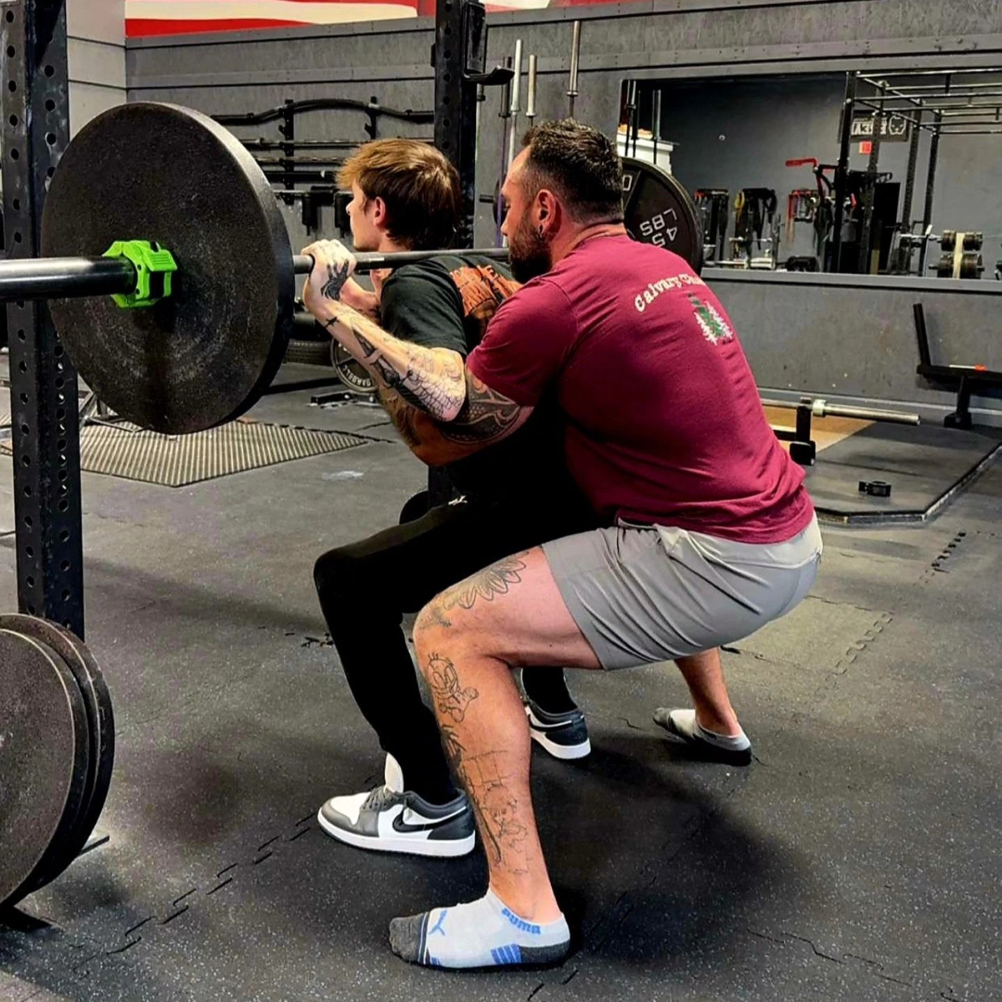A woman is doing push ups with a trainer in a gym