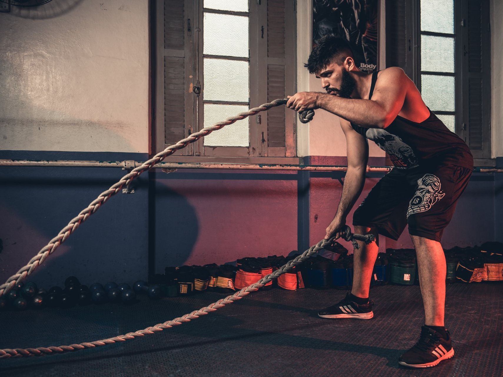 A man is holding a rope in a gym.
