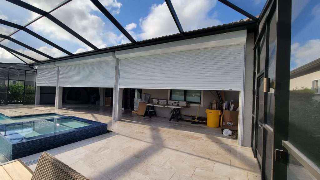 There Is a Swimming Pool in the Backyard of a House — Naples, FL — Wind Safe Shutters LLC