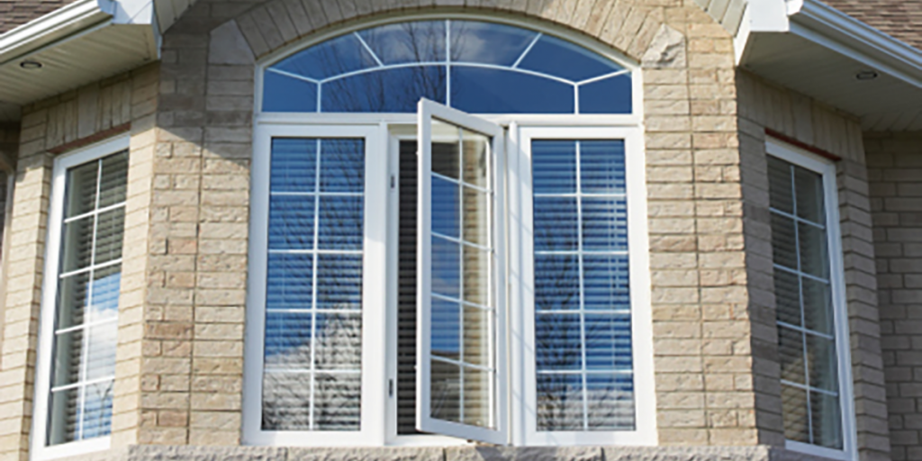 A Brick House With a Large Window With Blinds on It — Naples, FL — Wind Safe Shutters LLC