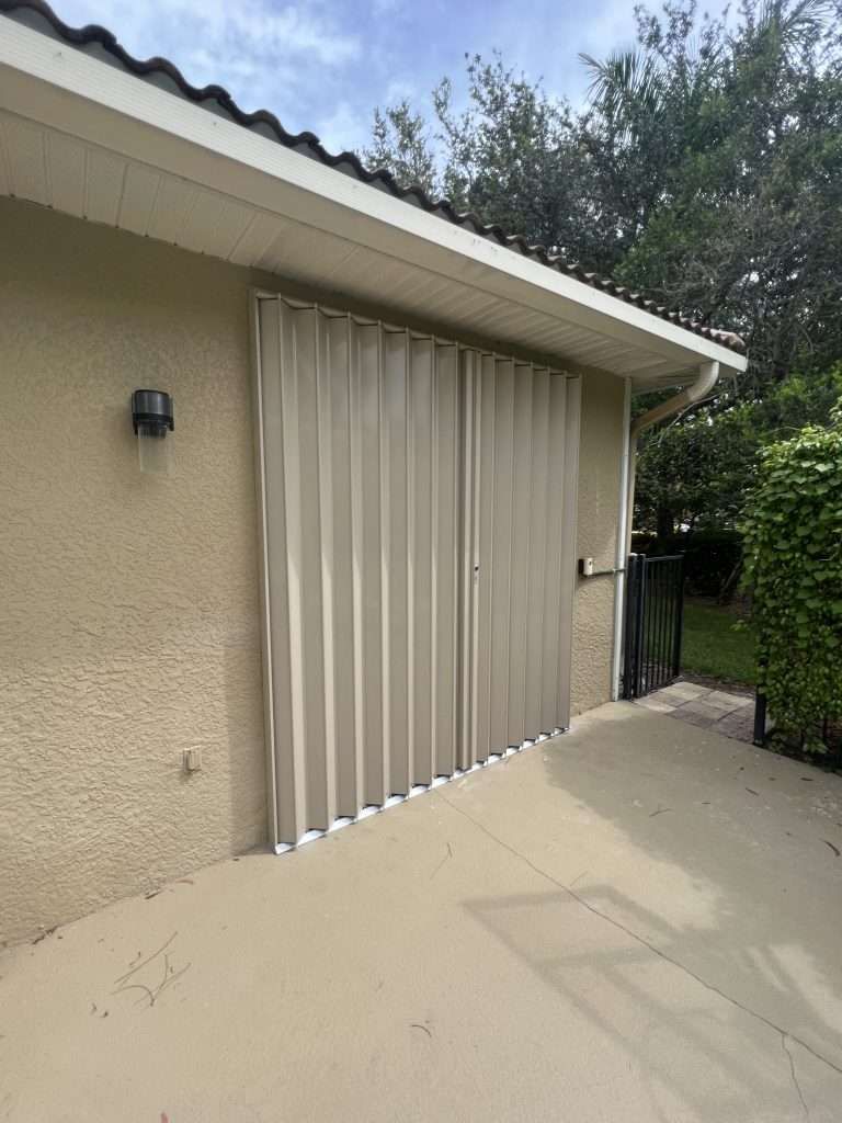 A House With a Patio and a Sliding Garage Door — Naples, FL — Wind Safe Shutters LLC